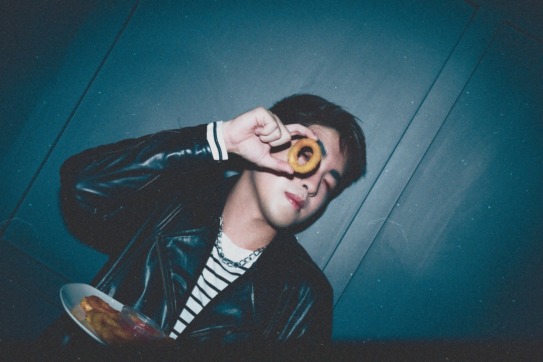 Stylish Young Man Holding Food Near His Eye